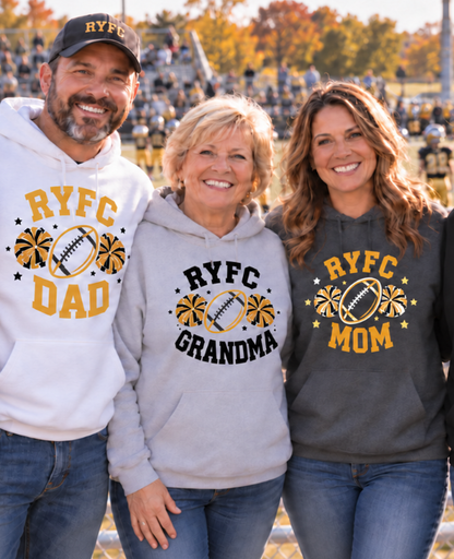 Three people standing together in a stadium wearing matching custom hoodies with 'RYFC' graphics. The man on the left wears a white hoodie labeled 'RYFC DAD', the middle person wears a light gray hoodie labeled 'RYFC GRANDMA', and the woman on the right wears a dark gray hoodie labeled 'RYFC MOM'.