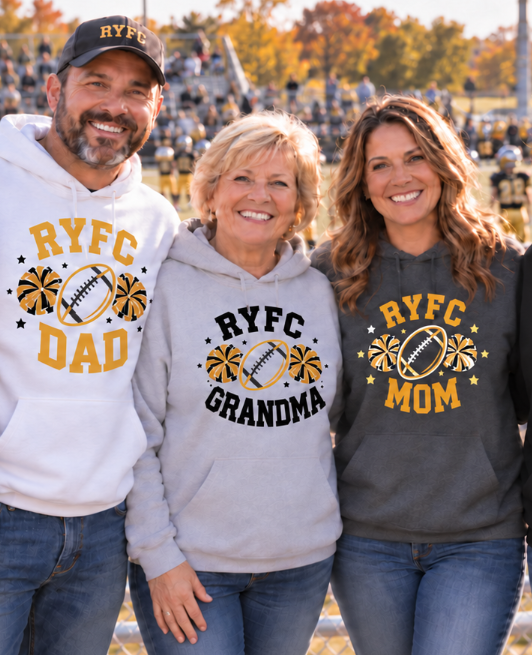 Three people standing together in a stadium wearing matching custom hoodies with 'RYFC' graphics. The man on the left wears a white hoodie labeled 'RYFC DAD', the middle person wears a light gray hoodie labeled 'RYFC GRANDMA', and the woman on the right wears a dark gray hoodie labeled 'RYFC MOM'.
